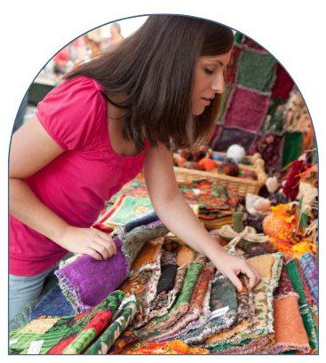 A woman looking at fabrics on display in a store.