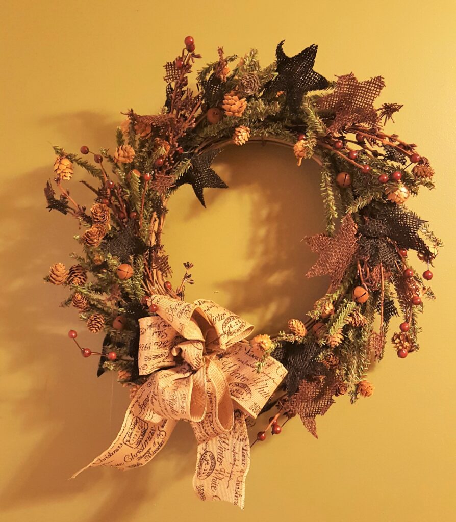 A wreath with leaves and flowers on it.