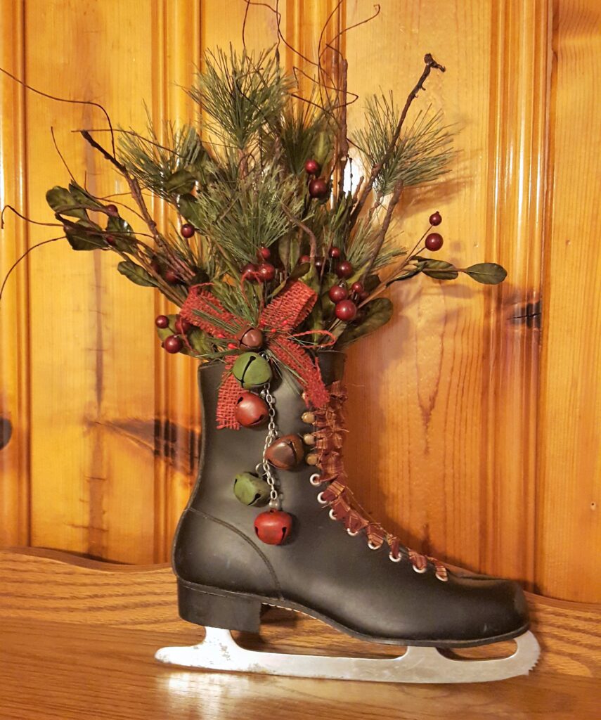 A black boot with red and green decorations on it.