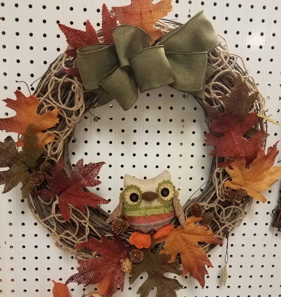 A wreath with leaves and an owl on it.