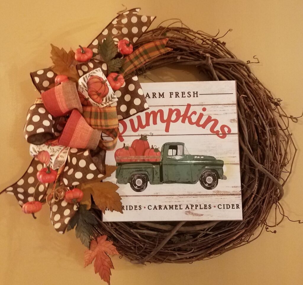 A wreath with a picture of a truck and leaves.