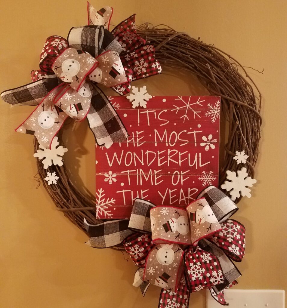 A wreath with red and white ribbons, bows and snowflakes.