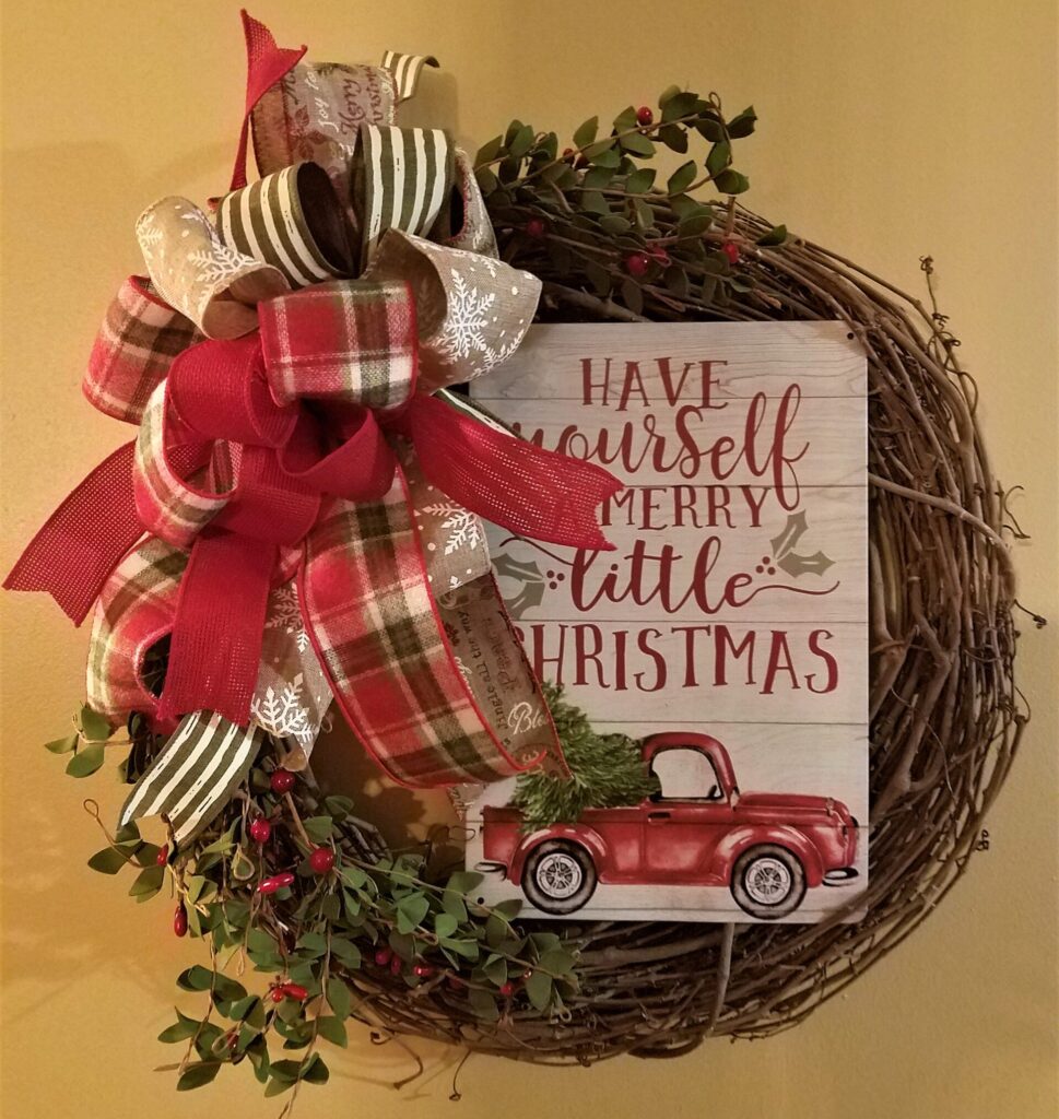 A wreath with a red truck and some green leaves