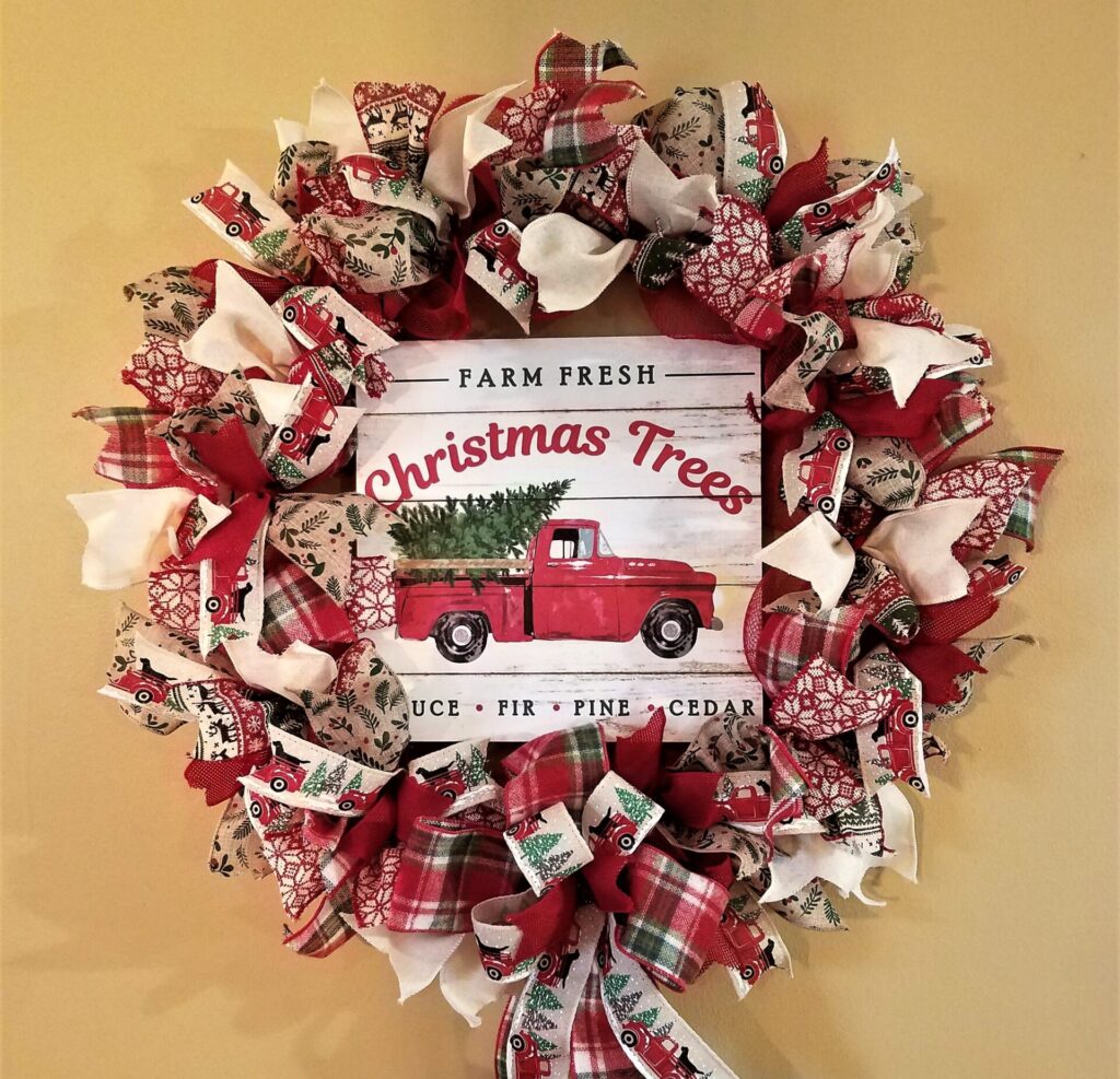 A wreath with ribbon and a red truck.