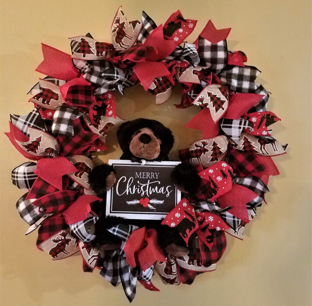 A christmas wreath with red and black ribbons