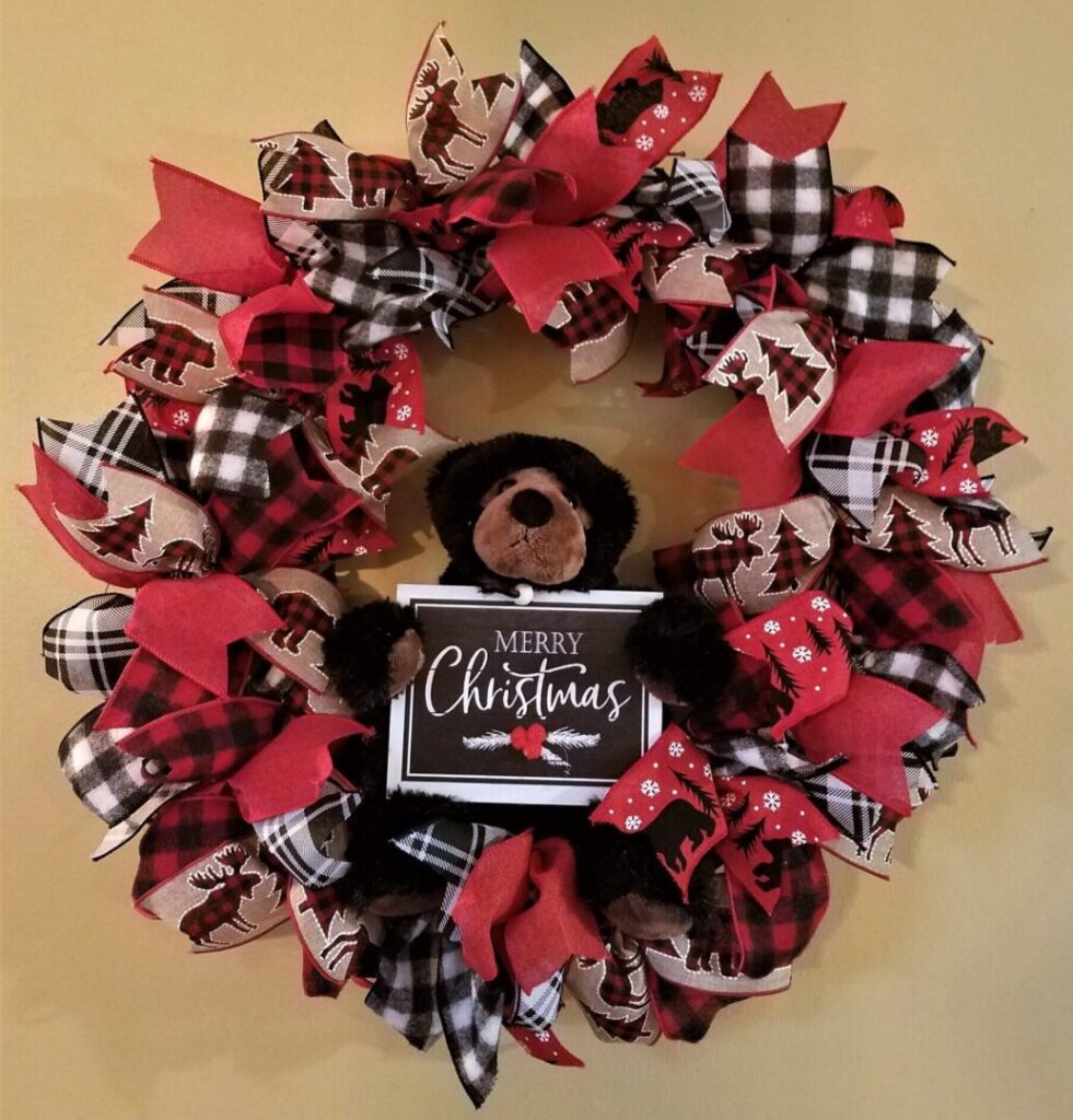 A christmas wreath with red and black ribbons