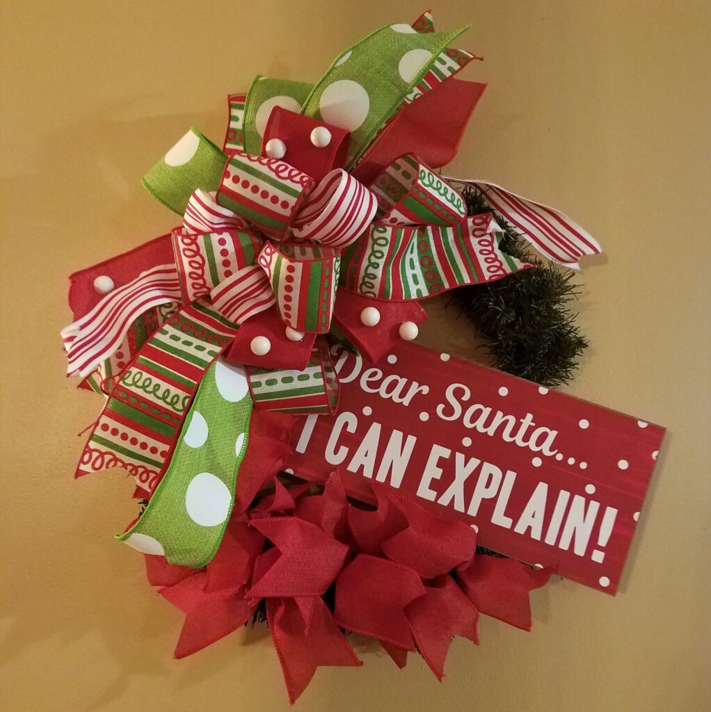 A christmas wreath with red and green ribbons.