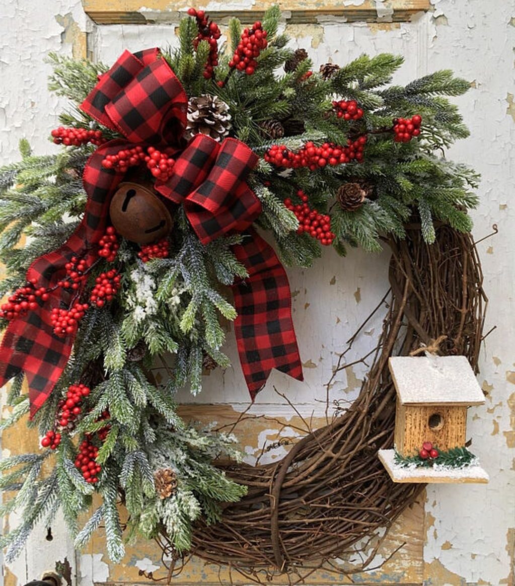 A wreath with pine branches and red ribbon.