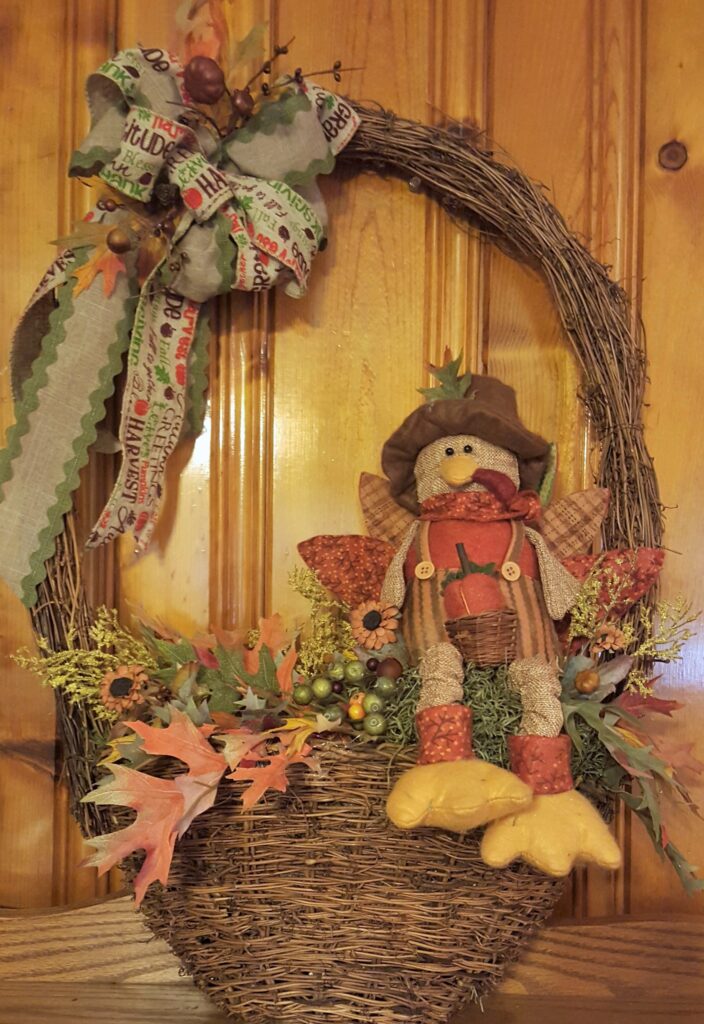 A wreath with a scarecrow sitting in it.