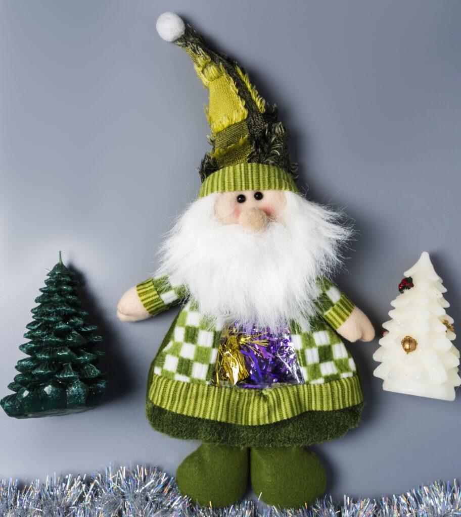 A green gnome with trees and candles on the table.