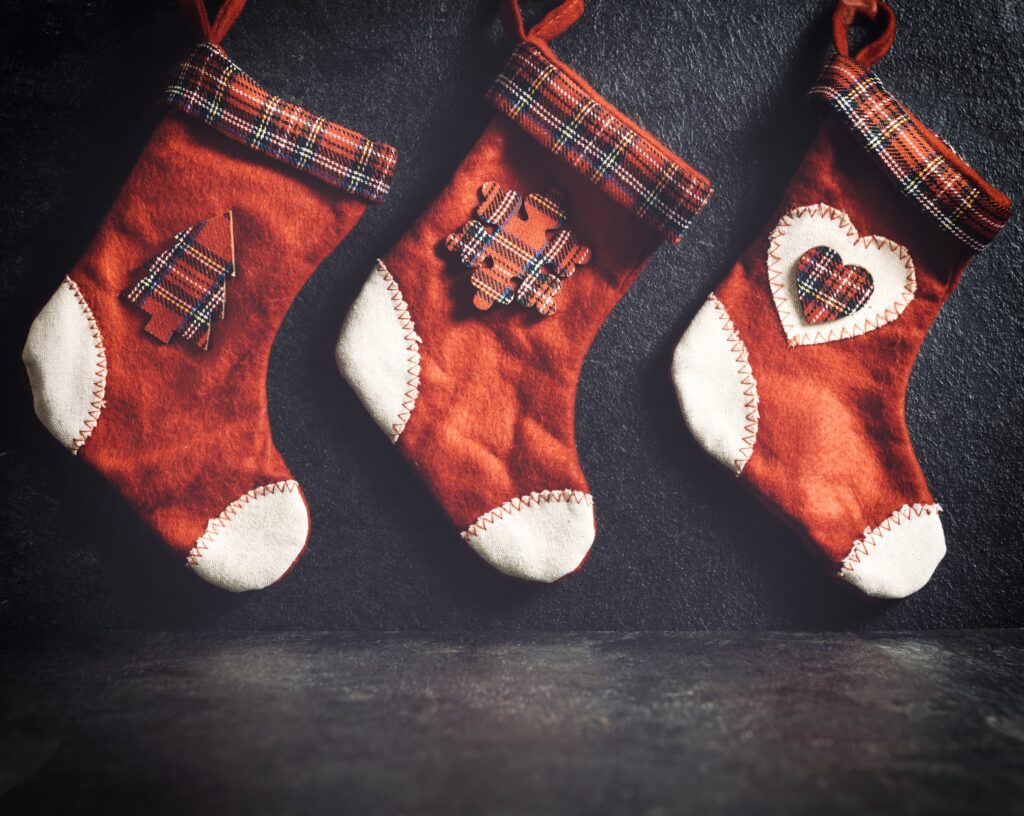 Three red and white christmas stockings on a table.