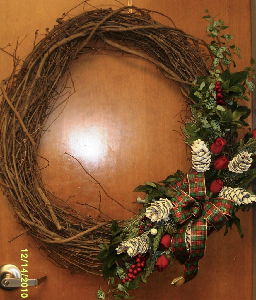 A wreath is sitting on the table with leaves and berries.