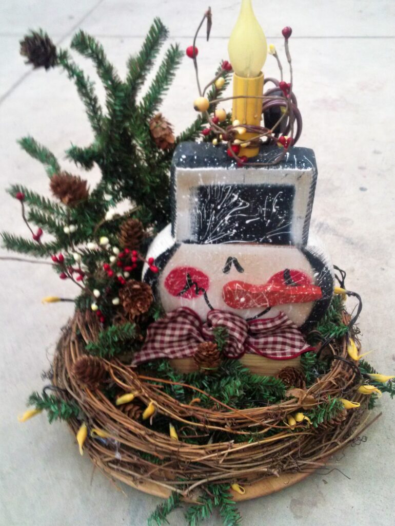 A small christmas tree with a wreath and some decorations