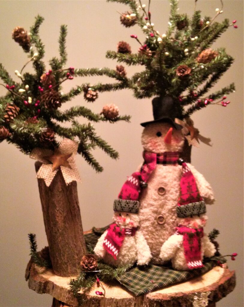 A christmas tree with a snowman on top of it.