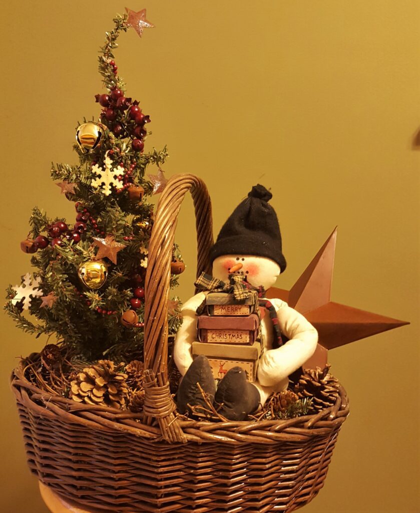 A basket with a small tree and a snowman.