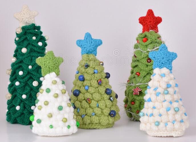 A group of christmas trees made out of yarn.