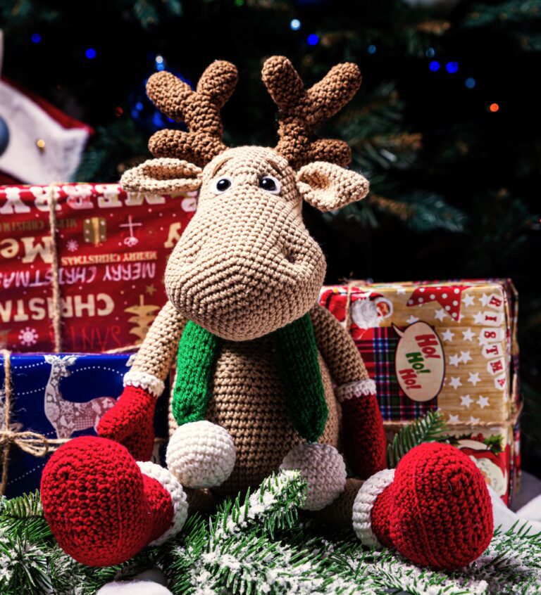 A stuffed animal sitting in front of christmas presents.