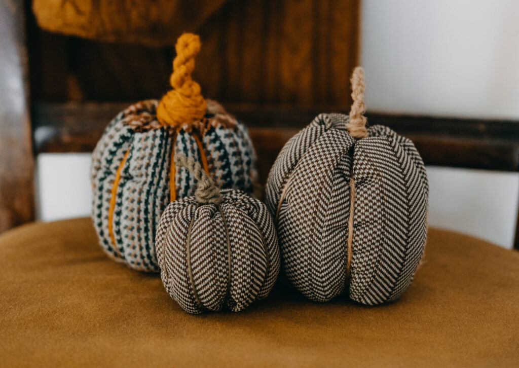 Three fabric pumpkins sitting on top of a table.