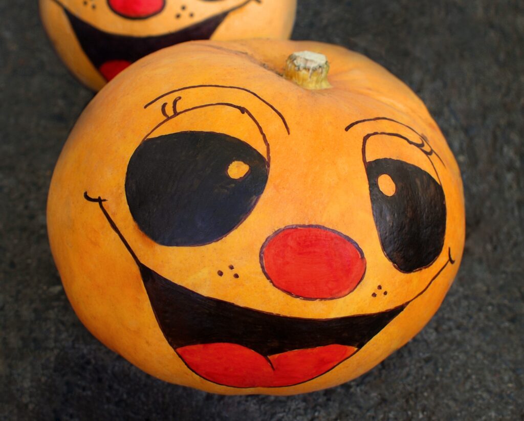 A pumpkin with an orange face painted on it.