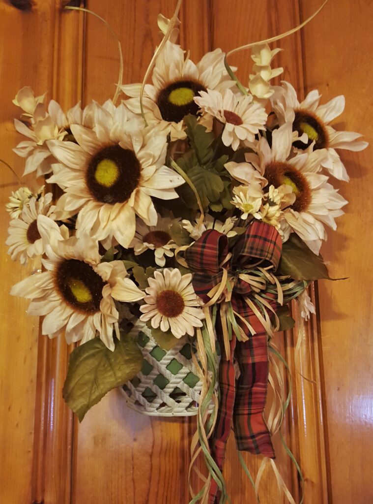 A basket of sunflowers hanging on the wall.