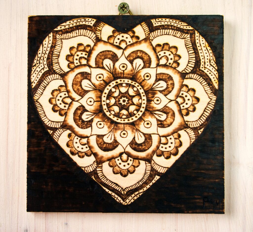 Woodburned mandala heart artwork.