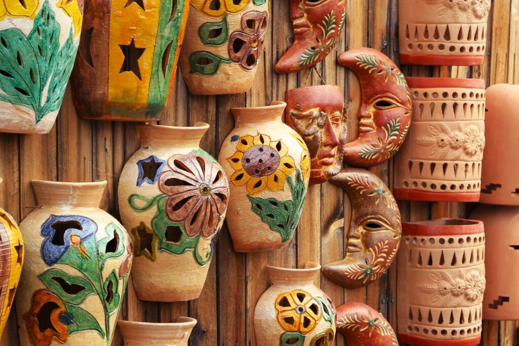 Hand-painted pottery and masks on display.