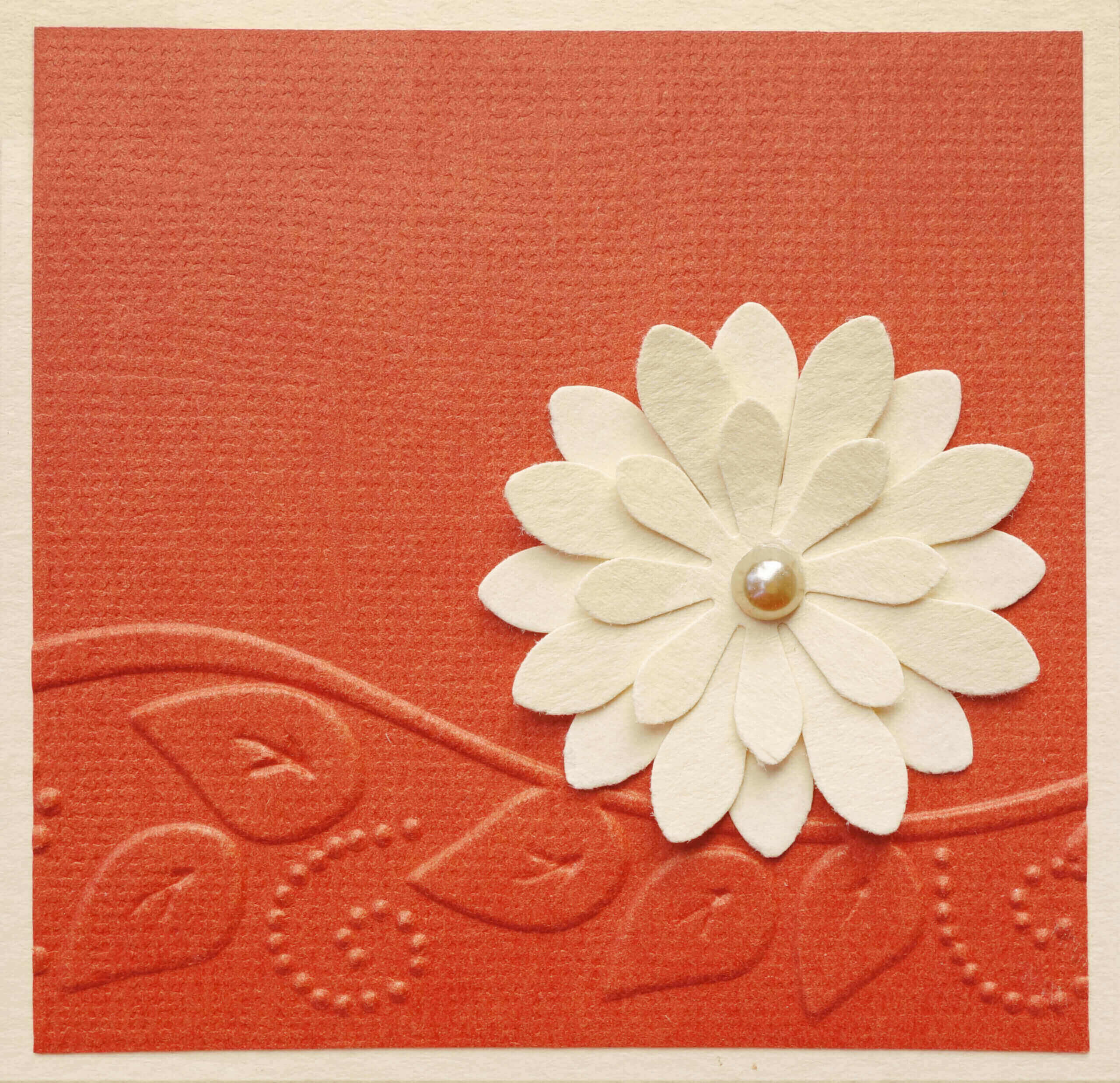 Orange card with off-white flower.