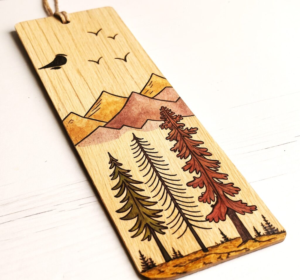 Wooden bookmark: mountains, trees, bird.