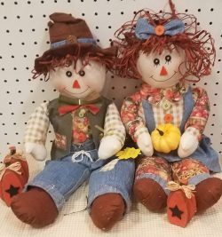 Two raggedy ann dolls sitting next to each other.